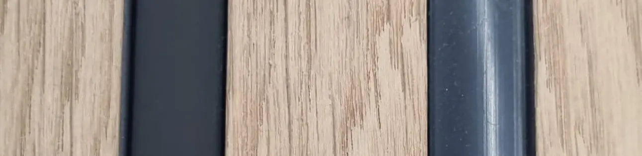 Close up of a wood slat wall with dark vertical trim used to illustrate lighting.