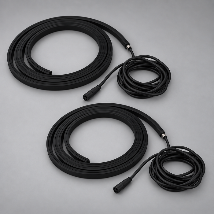 Two unlit black BLAQ IRIS LED strips shown coiled with their connection leads
